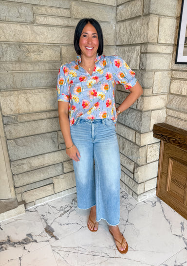 Periwinkle blue blouse with bright colored flower print
ruffle neckline and puff sleeves