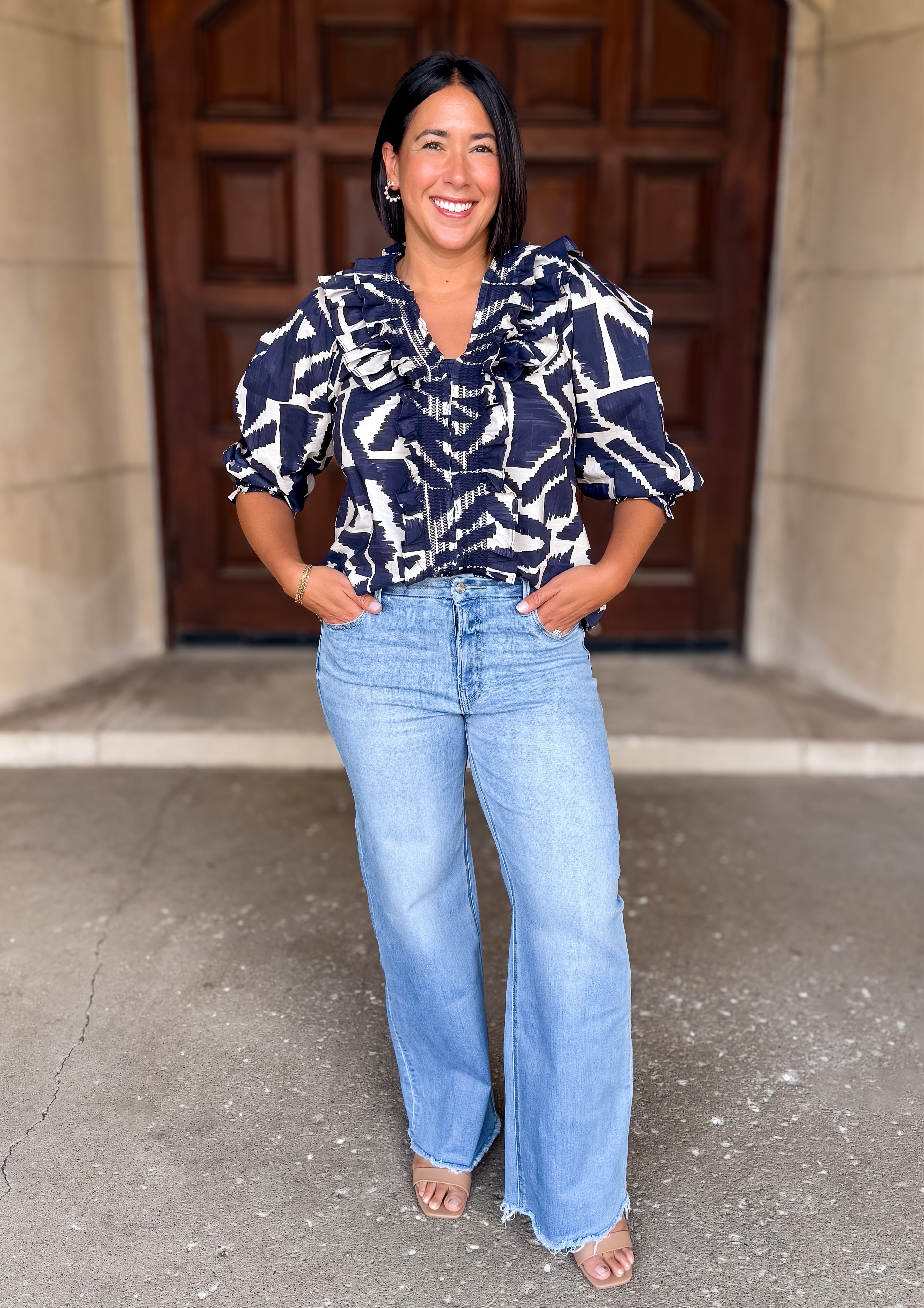 Printed
V-Neckline
Smocked Ruffle Trim and Cuff
3/4 Puff Sleeve
Dark Navy