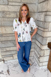 White floral print blouse with buttons and pintuck.