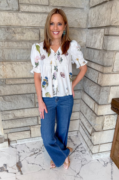 White floral print blouse with buttons and pintuck.