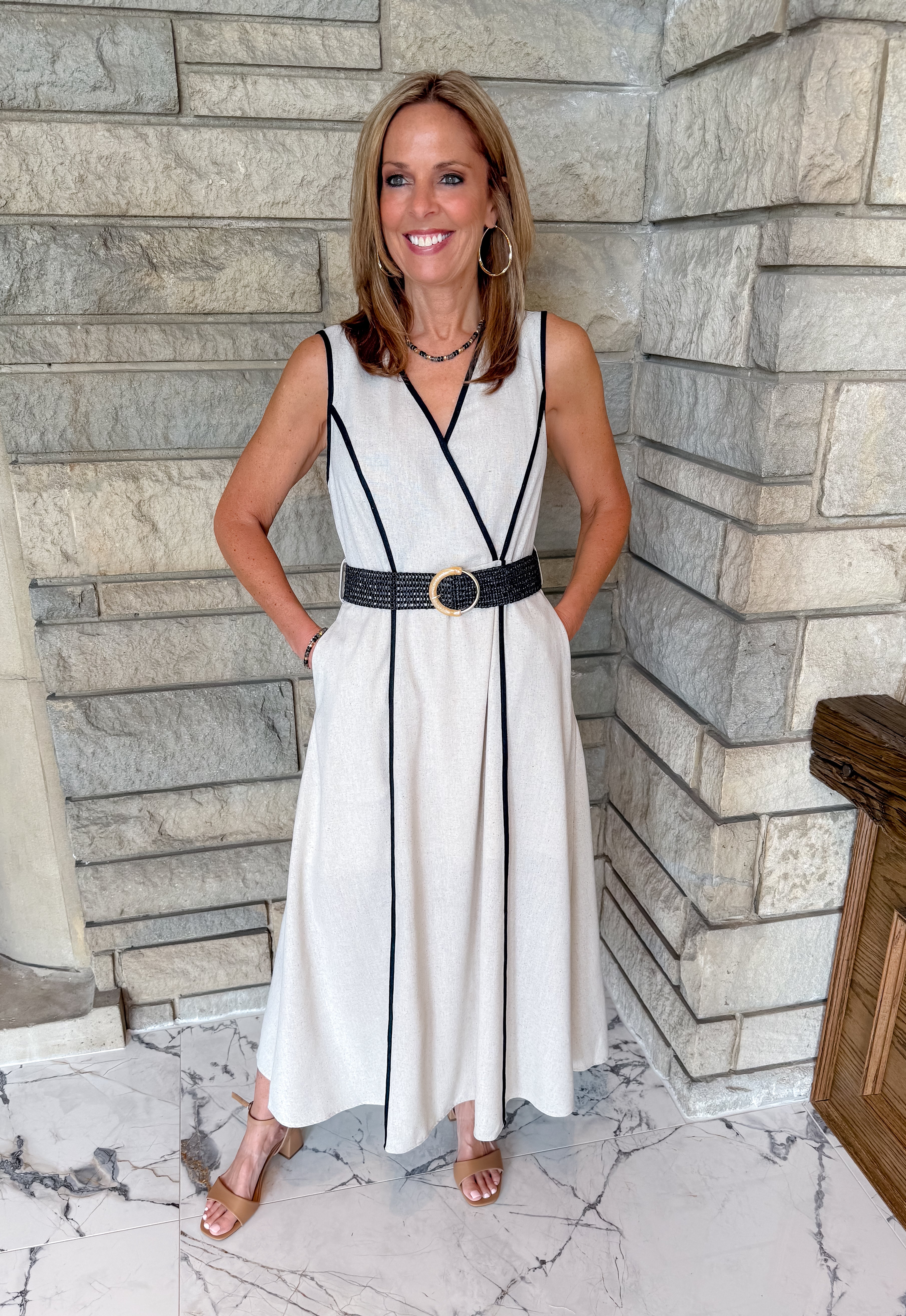 natural color dress with black trim
black trim detail
black woven belt with gold buckle