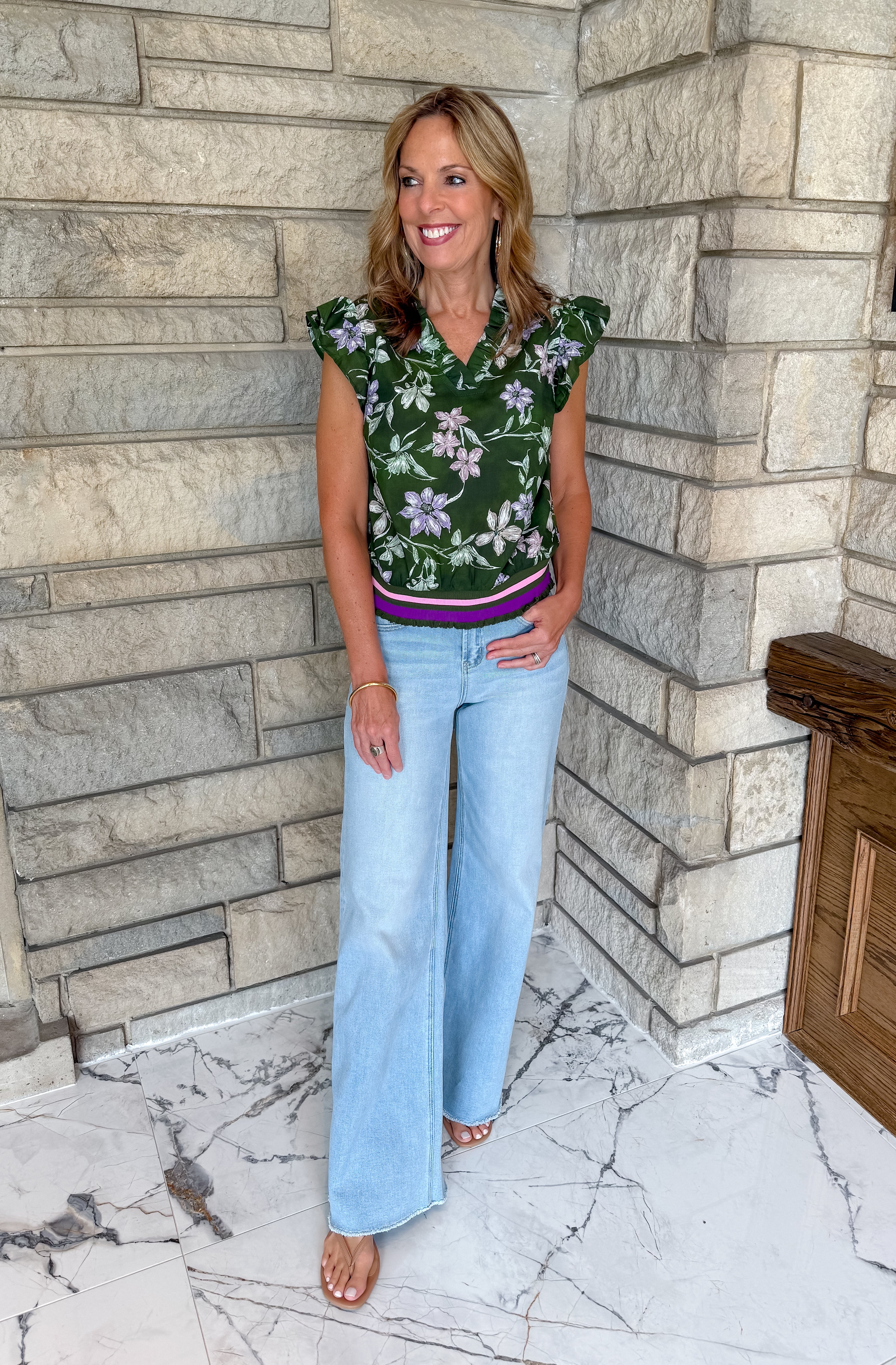 dark green sleeveless blouse with floral print ruffle sleeves and striped elastic band hem 
